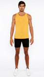 Man wearing a yellow tank top and black shorts on a white background
