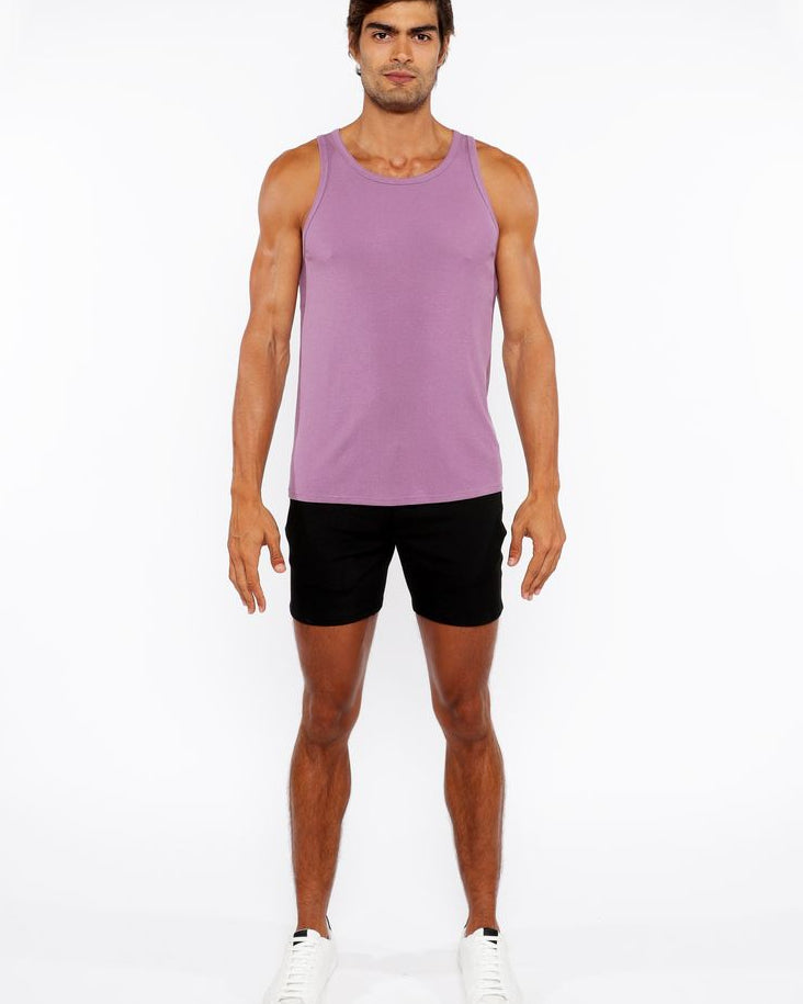 Man wearing a purple tank top and black shorts on a white background