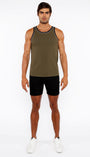 Man wearing an olive green tank top and black shorts on a white background