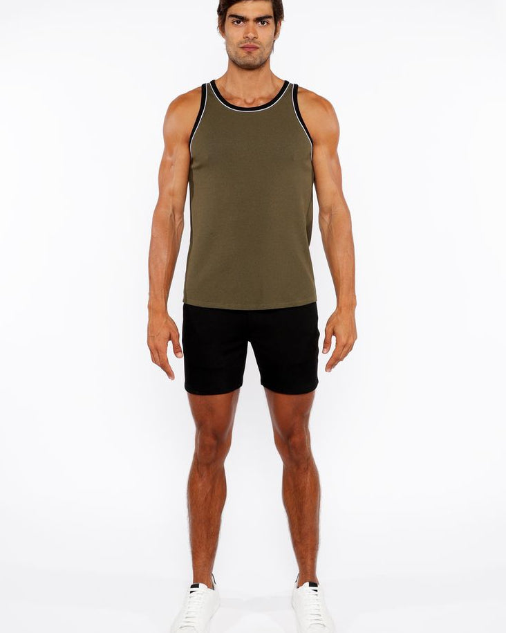 Man wearing an olive green tank top and black shorts on a white background