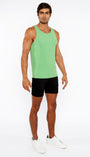 Man wearing a green tank top and black shorts on a white background