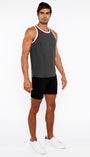 Man wearing a gray tank top and black shorts on a white background