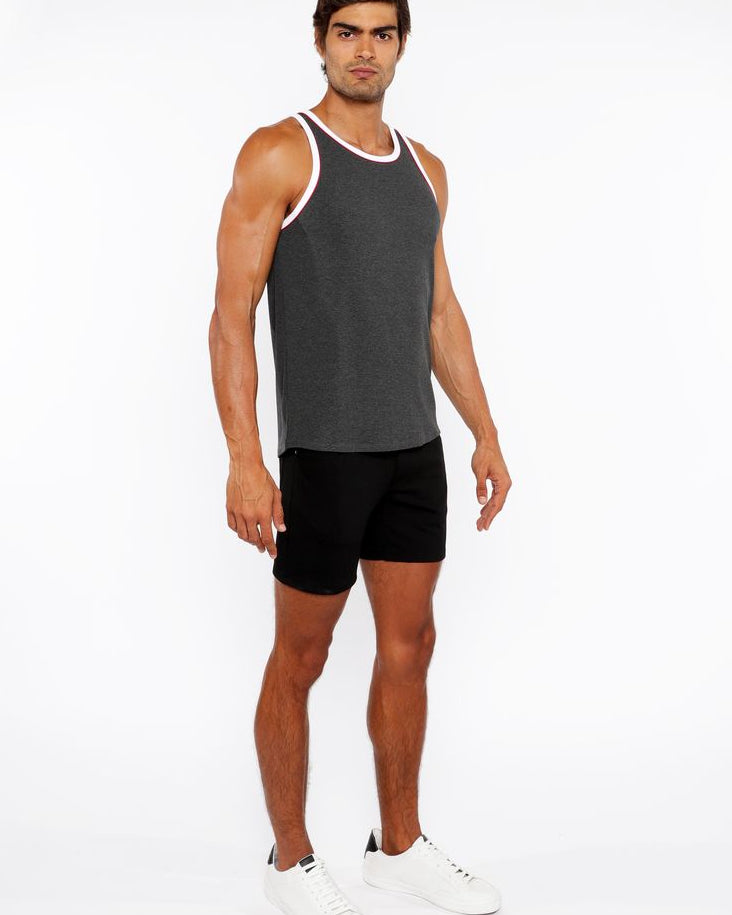 Man wearing a gray tank top and black shorts on a white background