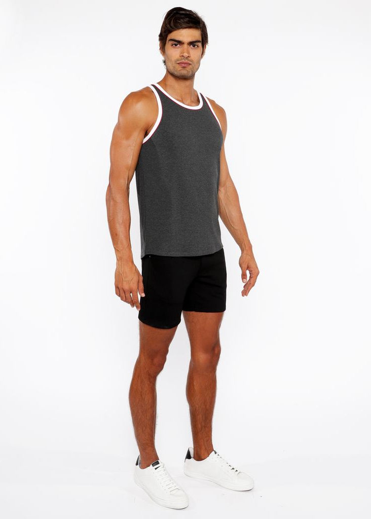 Man wearing a gray tank top and black shorts on a white background