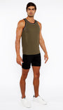 Man wearing a green tank top and black shorts on a white background