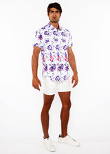 Man wearing a floral shirt and white shorts on a white background