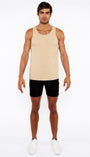 Man wearing a beige tank top and black shorts on a white background