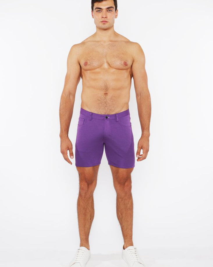 Man wearing purple shorts on a white background