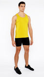 Man wearing a yellow tank top and black shorts on a white background