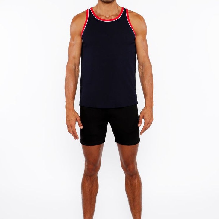 Man wearing a black tank top with red trim and black shorts on a white background