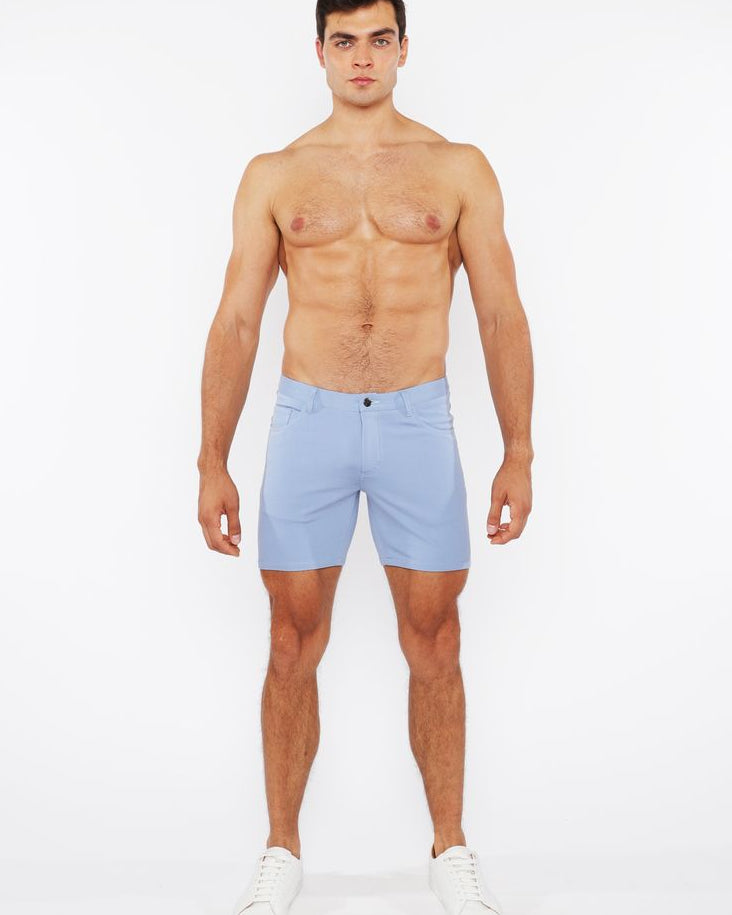 Man wearing light blue shorts on a white background