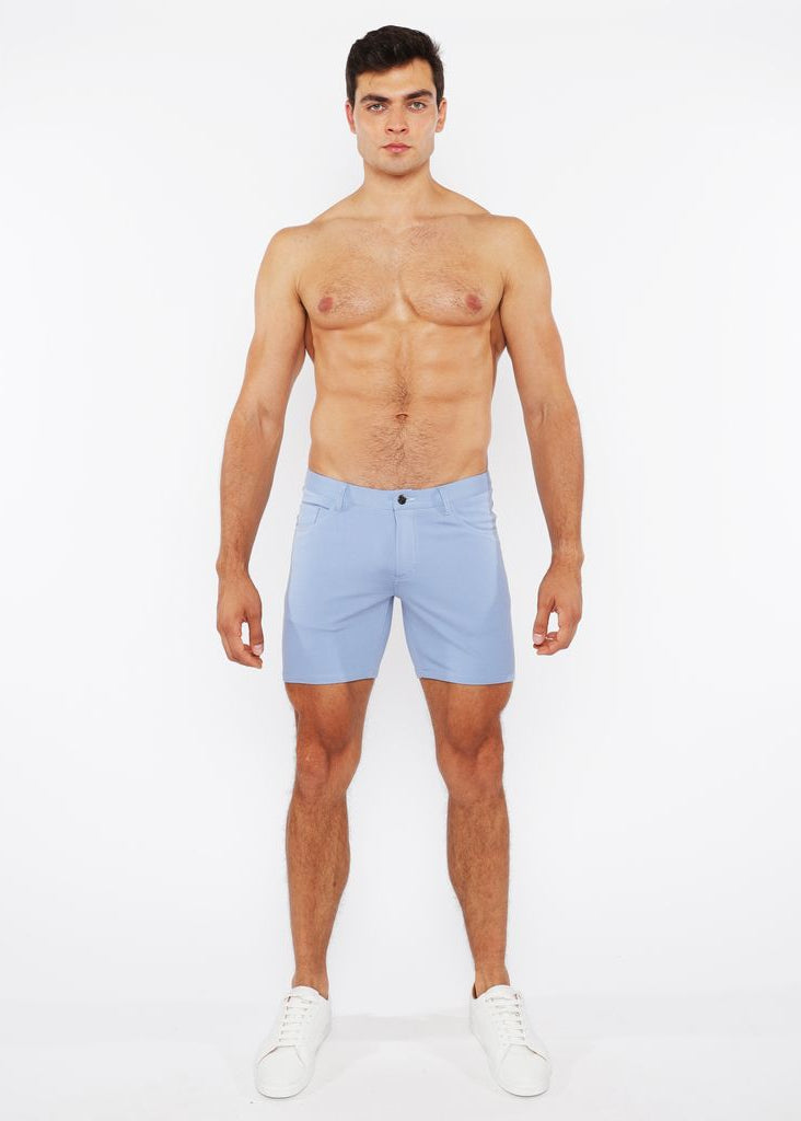Man wearing light blue shorts on a white background