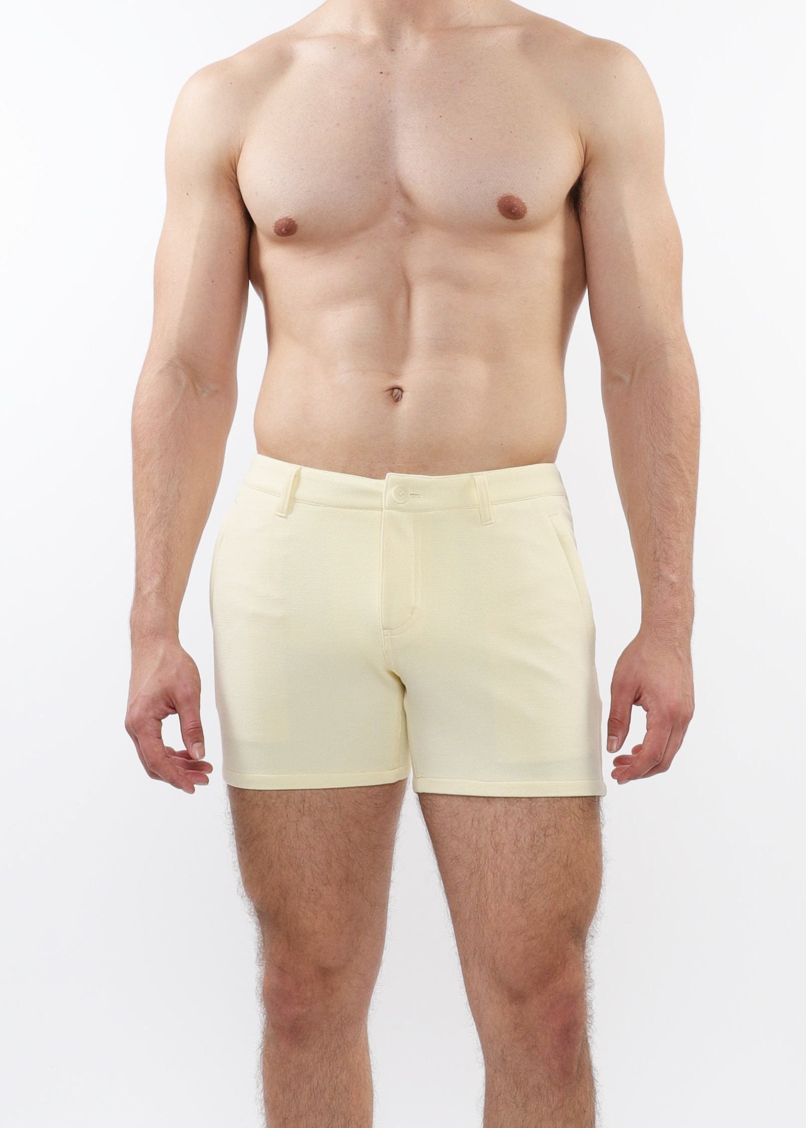 A model wearing cream-colored chino shorts with a slim fit and a 5-inch inseam, paired with white sneakers.