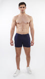 A model wearing navy blue chino shorts with a zipper fly and slim fit, standing against a white background.