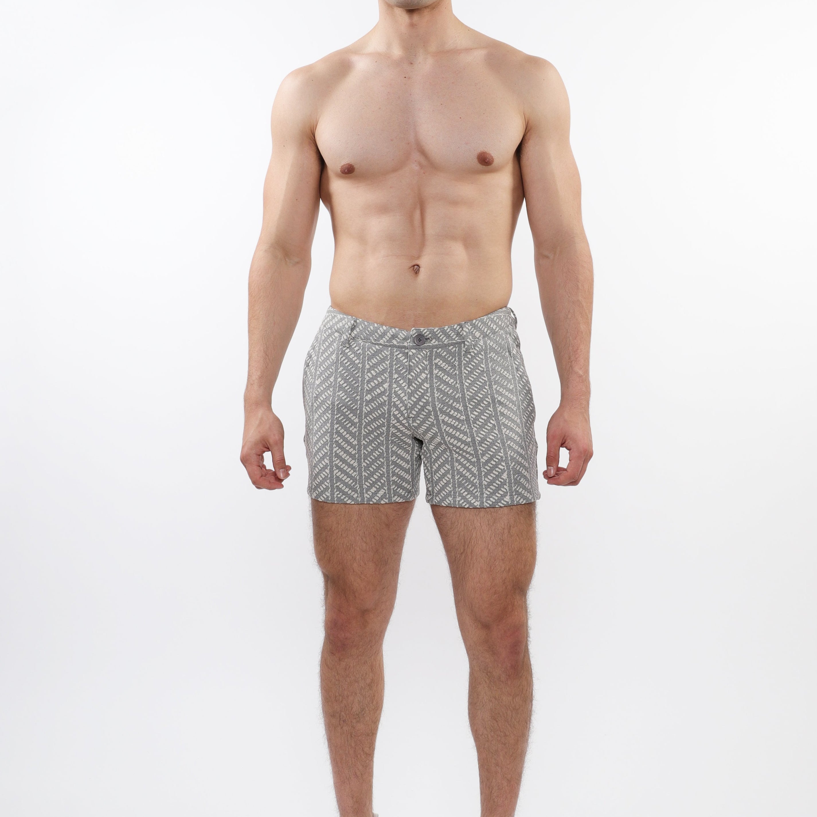 A model wearing ecru and black herringbone patterned chino shorts with zip pockets.