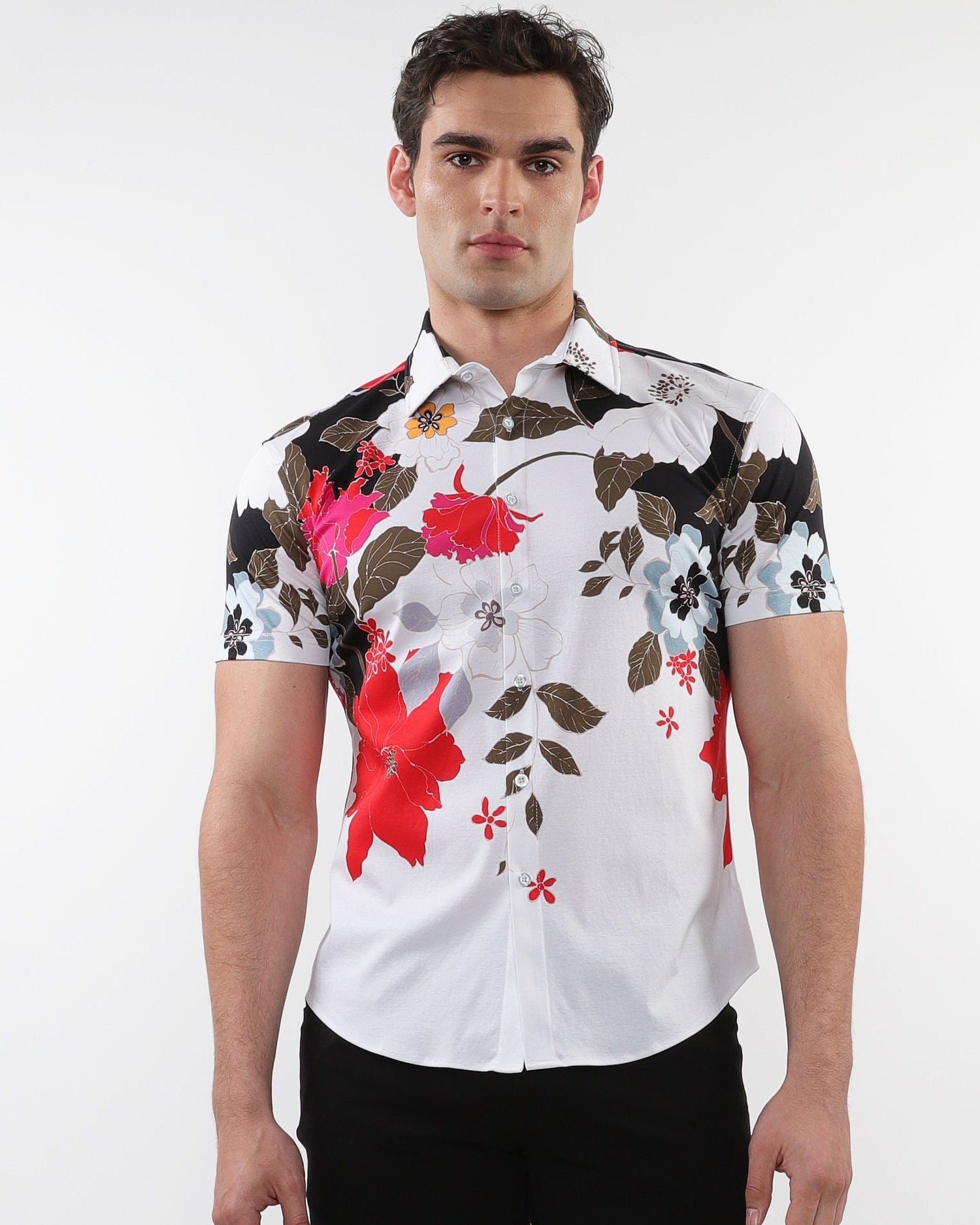A male model wearing a white short sleeve knit jersey shirt with black, red, and sky blue floral border prints.