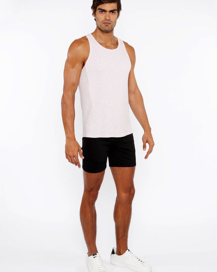 Man wearing a white tank top and black shorts on a white background