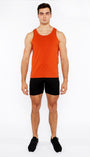 Man wearing an orange tank top and black shorts on a white background