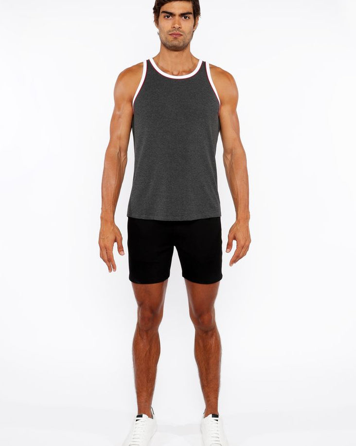 Man wearing a gray tank top and black shorts on a white background