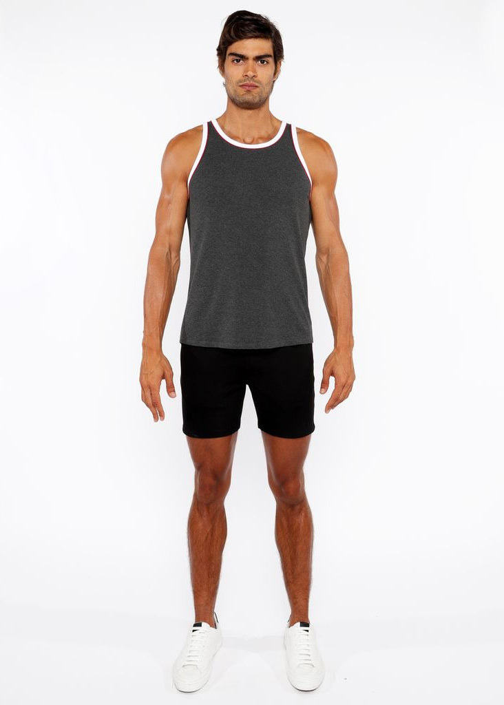 Man wearing a gray tank top and black shorts on a white background