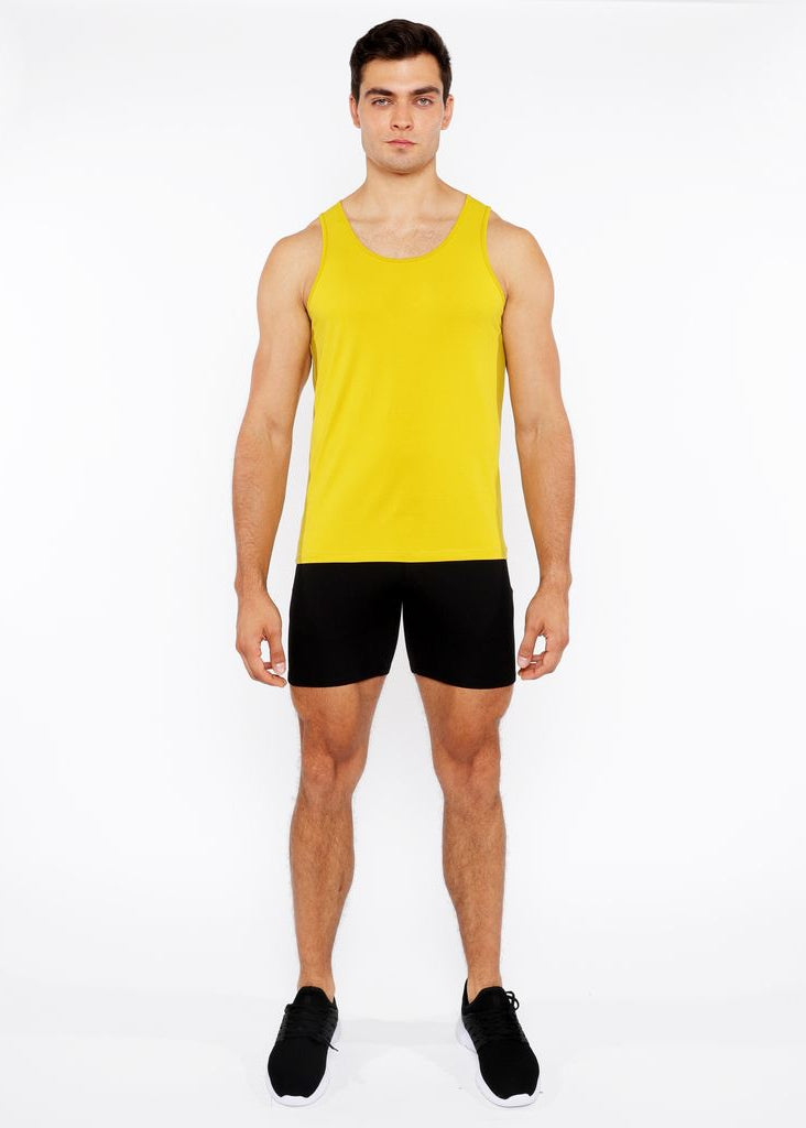 Man wearing a yellow tank top and black shorts on a white background