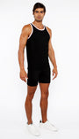 Man wearing a black tank top and shorts on a white background