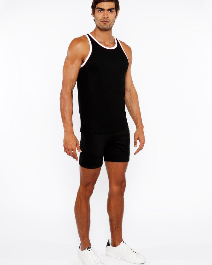 Man wearing a black tank top and shorts on a white background