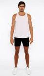 Man wearing a white tank top and black shorts on a white background