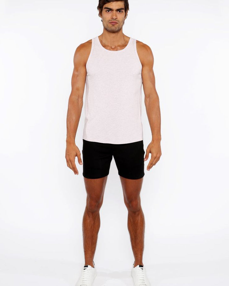 Man wearing a white tank top and black shorts on a white background