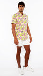 Man wearing a colorful floral shirt and white shorts on a white background