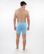 Back view of a man wearing ST33LE mens pale blue stretch shorts with white sneakers