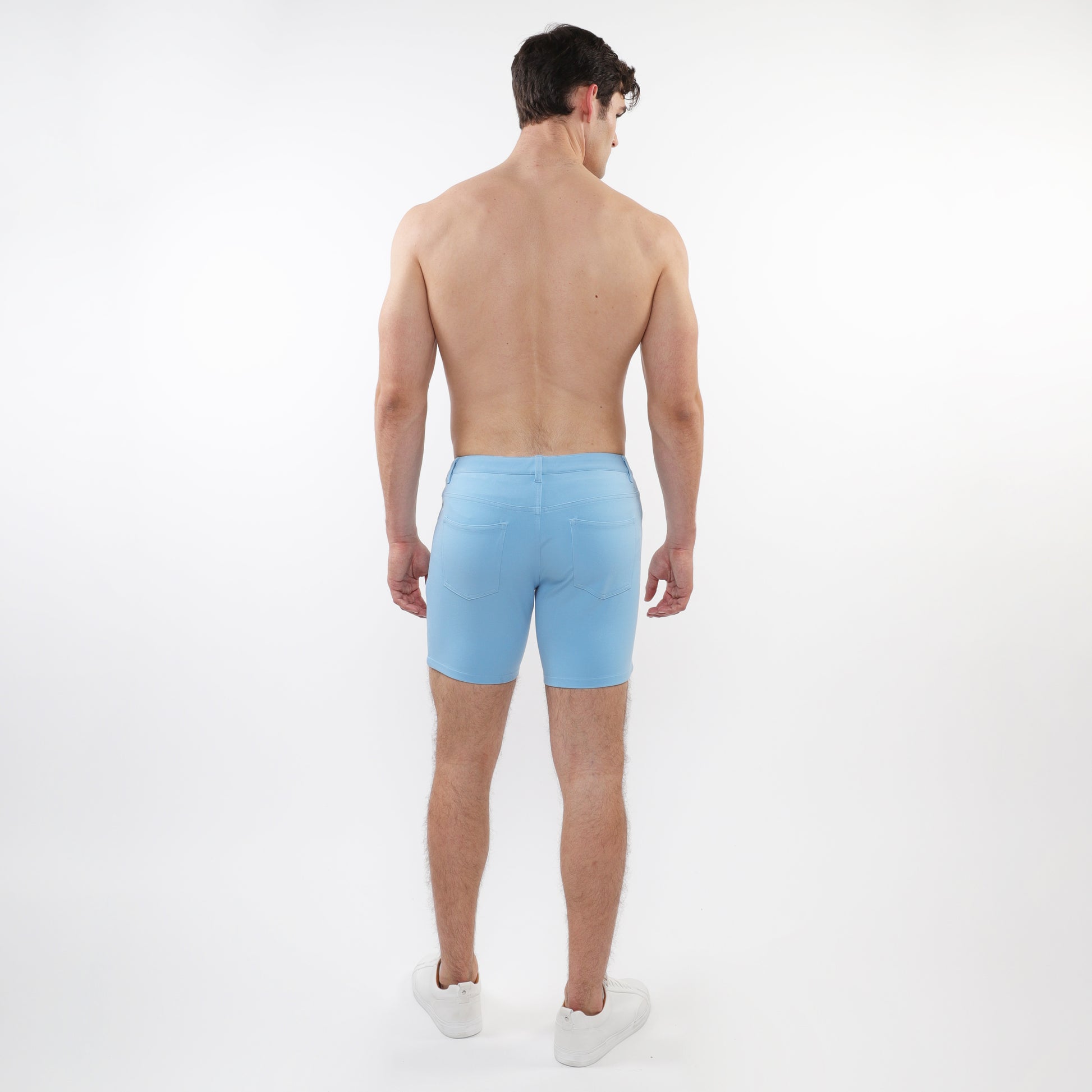 Back view of a man wearing ST33LE mens pale blue stretch shorts with white sneakers