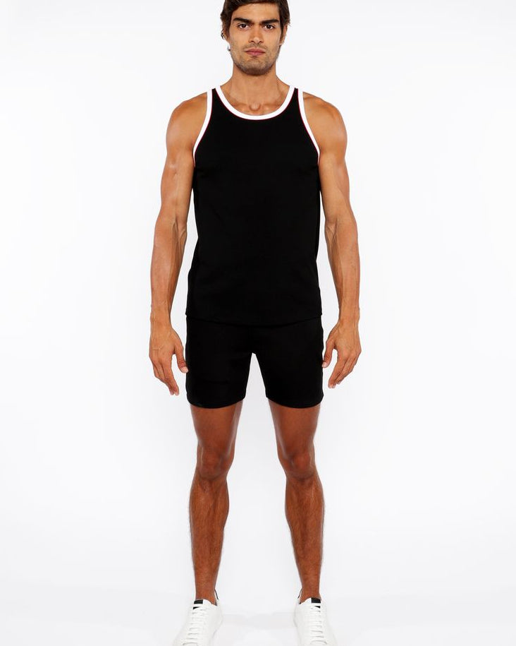 Man wearing a black tank top and shorts on a white background