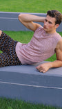 Person stretching on a track and field lane with grass in the background