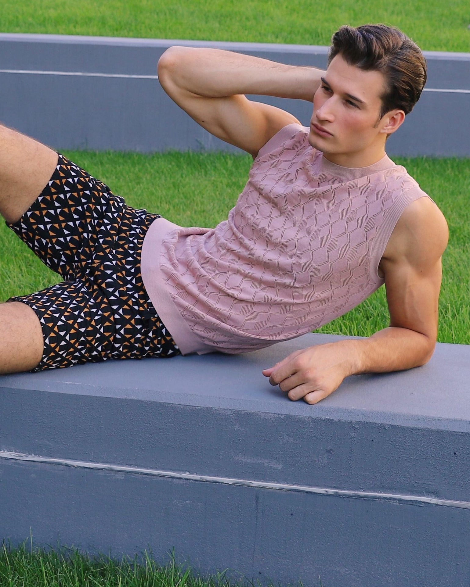 Person stretching on a track and field lane with grass in the background