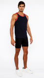 Man wearing a black tank top with red trim and black shorts on a white background