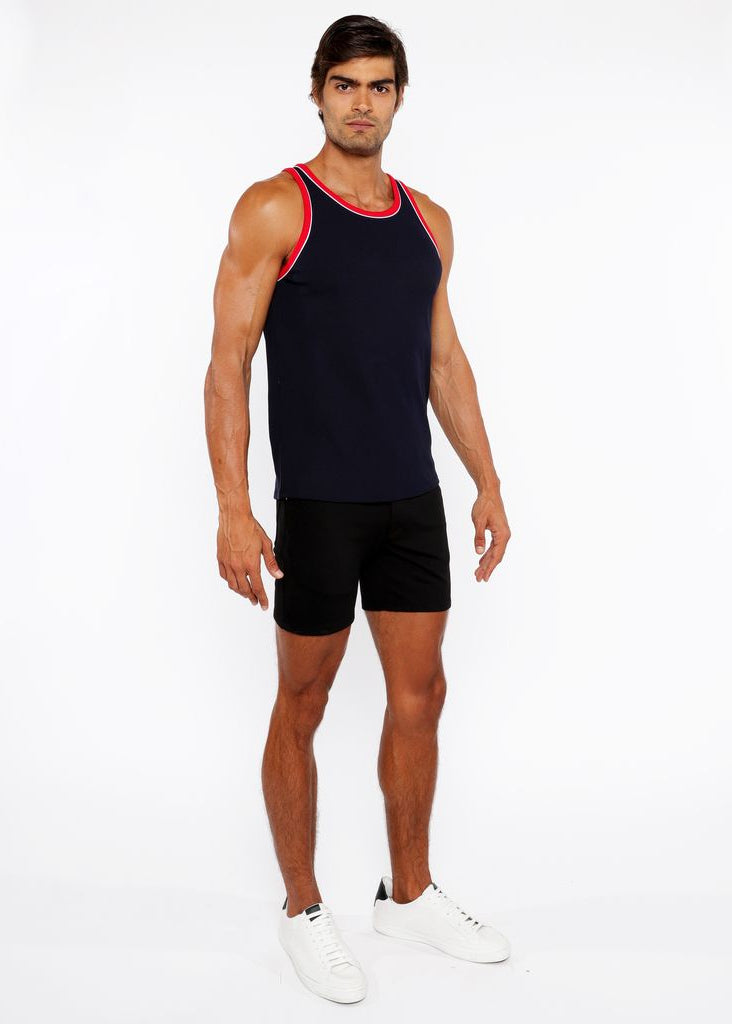 Man wearing a black tank top with red trim and black shorts on a white background