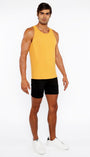 Man wearing a yellow tank top and black shorts on a white background