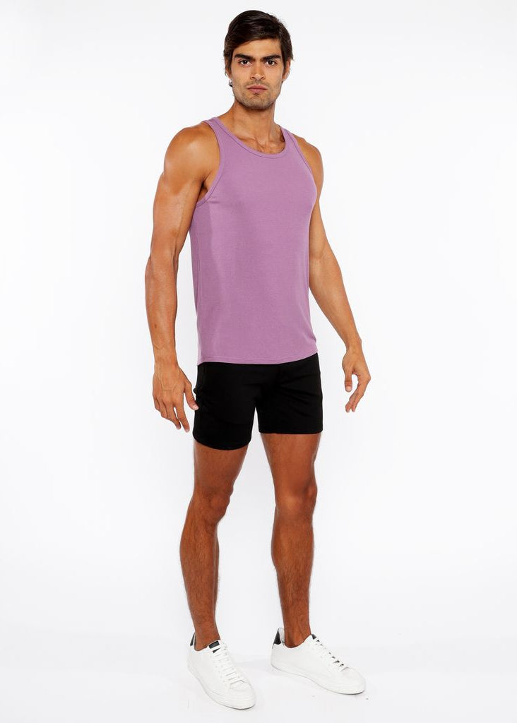 Man wearing a purple tank top and black shorts on a white background